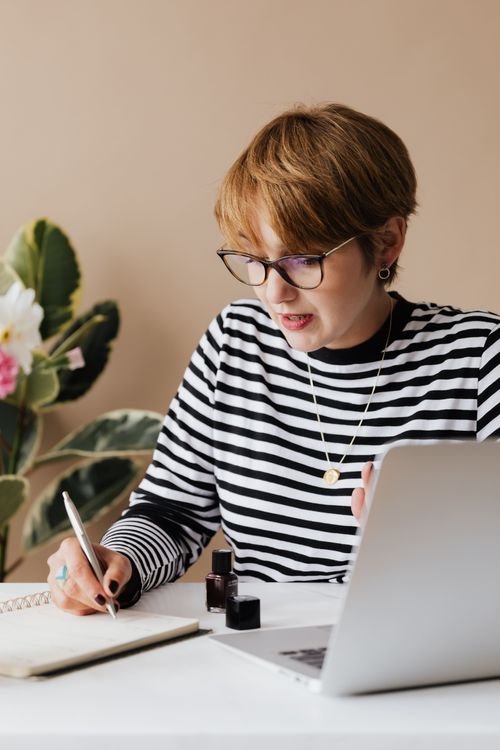 Femme concentrée écrivant des notes.